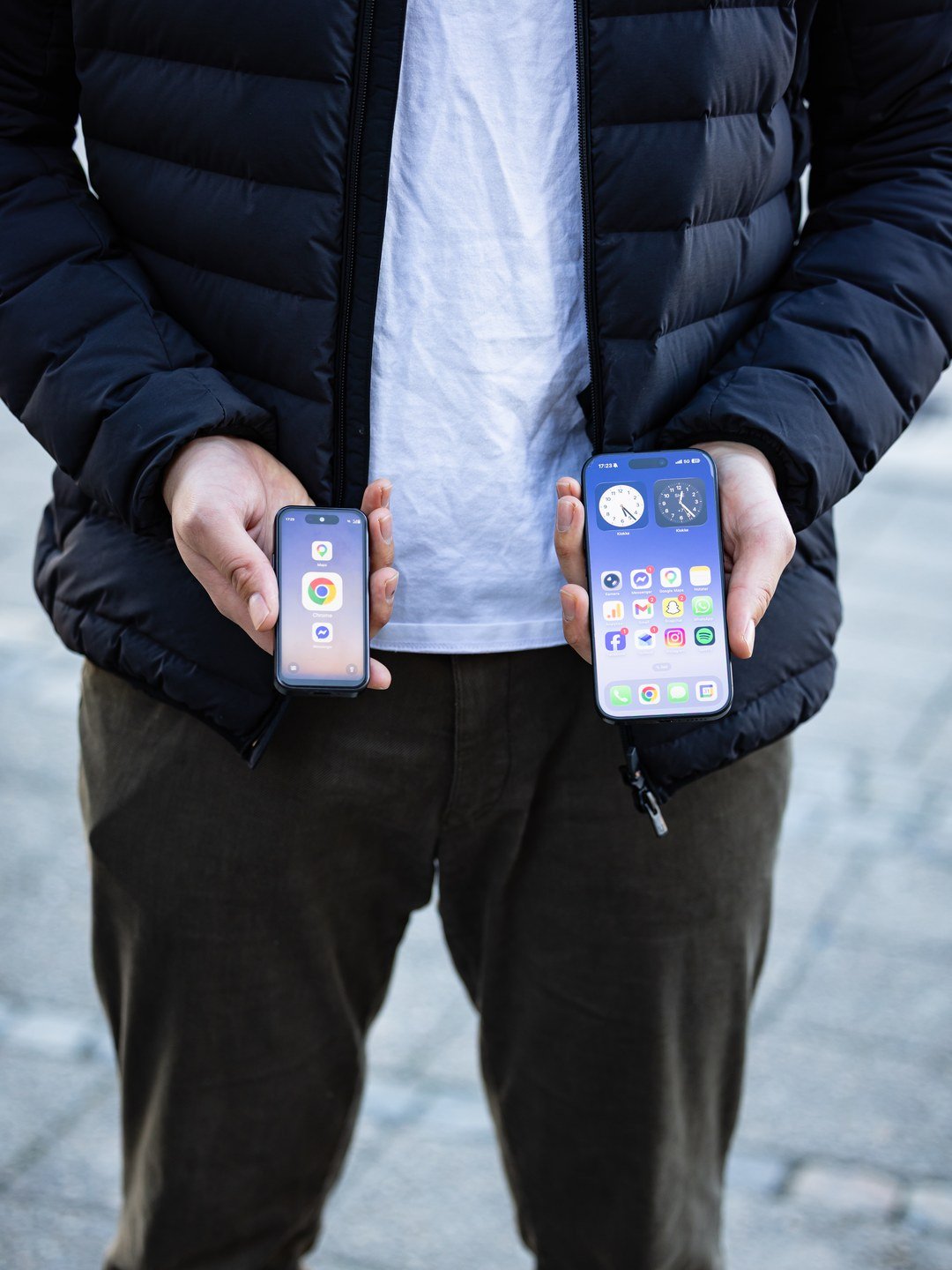 To telefoner i hendene — en vanlig telefon full av app-varsler, ved siden av en AEROS Juno med rolig, ren skjerm uten varsler.